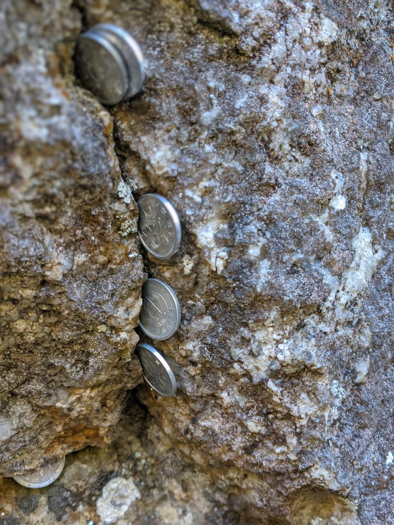 ¥1 coins left in the rock formation